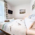 Bedroom with bed, TV, and window with curtains.
