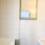 Badezimmer mit Badewanne, Spiegel und Waschbecken.