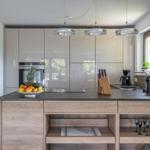 Moderne Küche mit Holzinsel, Glasküchen und Obstschale.