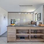 Küche mit Holzinsel, Schränken und Fensterblick