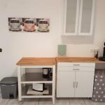 Küchenbereich mit Arbeitsfläche, Schrank und Kaffeemaschine.