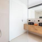 Bad mit Dusche, zwei Waschbecken und Holzwaschtisch