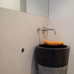 Dusche mit schwarzer Sitzbank und orangefarbenem Handtuch