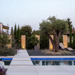Pool mit Steinweg, Olivenbaum und Beleuchtung im Garten
