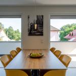 Esszimmer mit Holztisch, gelben Stühlen und Blick auf Balkon