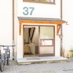Eingang mit Hausnummer 37, Fahrräder und Pflanzen vor der Tür.