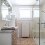Badezimmer mit Dusche, Waschbecken und Fenster