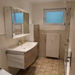 Badezimmer mit Waschbecken, Spiegelschrank, Dusche und Fenster