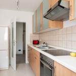 Küche mit Kühlschrank, Herd, Spüle und Küchenzeile.