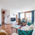 Wohn- und Essbereich mit Sofa, TV und Terrassentür.