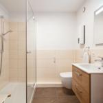Badezimmer mit Dusche, Waschbecken und Toilette.