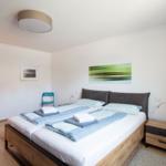 Schlafzimmer mit Doppelbett, Nachttisch und Wandbild