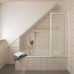Badezimmer mit Dusche, Badewanne und Fenster