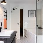 Badezimmer mit Dusche, Waschbecken und Wandfliesen