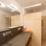 Badezimmer mit Dusche, Waschbecken und Spiegel