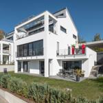 Moderne weiße Villa mit Terrasse und Garten.