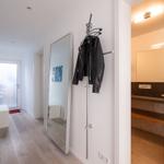 Flur mit Spiegel, Jacke und Blick in Bad