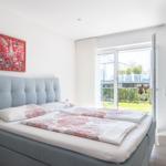 Schlafzimmer mit Bett, Fenster und Wandkunst