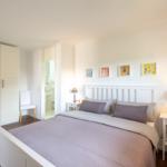 Schlafzimmer mit Bett, Nachttischen und Kleiderschrank. Badezimmer ist angebunden.