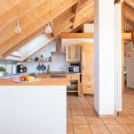 Küche mit Holzdecke und Treppe zur Galerie. Arbeitsplatte mit Obst.