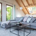 Wohnzimmer mit grauem Sofa, Tisch und Balkonblick.
