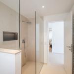 Dusche mit Glaswand, Handtuchhalter und Blick in Schlafzimmer