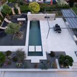 Poolbereich mit Loungebereich und modernem Pavillon im Garten.
