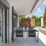Terrasse mit Esstisch, Garten und Blick ins Haus.