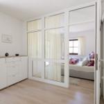 Schlafzimmer mit Schlafbereich und Schrank. Lichtdurchfluteter Raum mit Holzboden.