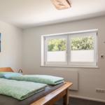 Schlafzimmer mit Doppelbett, Fenster und Wandbild