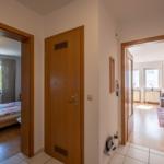 Hausgang mit Schlafzimmer und Wohnzimmer. Holztüren und helle Wände.