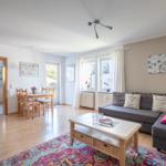 Wohn- und Essbereich mit Sofa, Esstisch und Blick in die Küche.