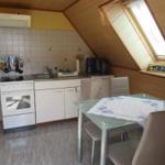 Küche mit Essbereich, Dachfenster und Küchenschränken.