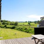 Terrasse mit Tisch und Blick auf grünes Feld und Himmel