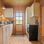 Küche mit Holzwand, Küchenzeile und Tür zum Garten.