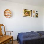 Ein Schlafzimmer mit einem Bett, einem Stuhl und Wanddekoration.