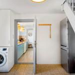 Wohnung mit Waschmaschine, Kühlschrank und Treppenhaus.