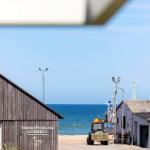 Fischerhaus Thorupstrand mit Blick aufs Meer und Fischerboot.