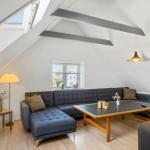Wohnzimmer mit Dachschrägen, Sofa, Tisch und Fenster