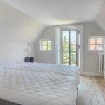 Schlafzimmer mit Dachschrägen, Bett, Schrank und Fenster zur Aussicht.
