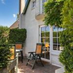 Terrasse mit Stuhl und Tisch vor einer Haustür mit Glasfenstern.