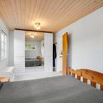 Schlafzimmer mit Holzboden, weißer Kleiderschrank und Holzbett.