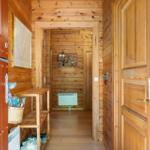 Holzgetäfelte Eingangshalle mit Schuhschrank und Karte an der Wand.