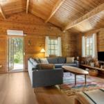 Wohnzimmer mit Holzwand, Sofa, Couchtisch und Fernseher