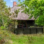 Haus mit Strohdach und Holzterrasse im Grünen