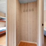 Zimmer mit Schlafplatz und Kleiderhaken an Holzwand