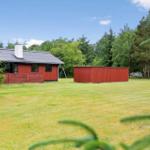 Rotes Ferienhaus mit Garten und Wald im Hintergrund.