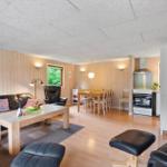 Wohn- und Essbereich mit Sofa, Stühlen und Küchenzeile.