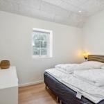 Schlafzimmer mit Doppelbett, Fenster und Wandlampe.