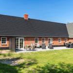Rotes Backsteingebäude mit Terrasse und Garten. Außentisch, Sitzgelegenheiten und Grill.
